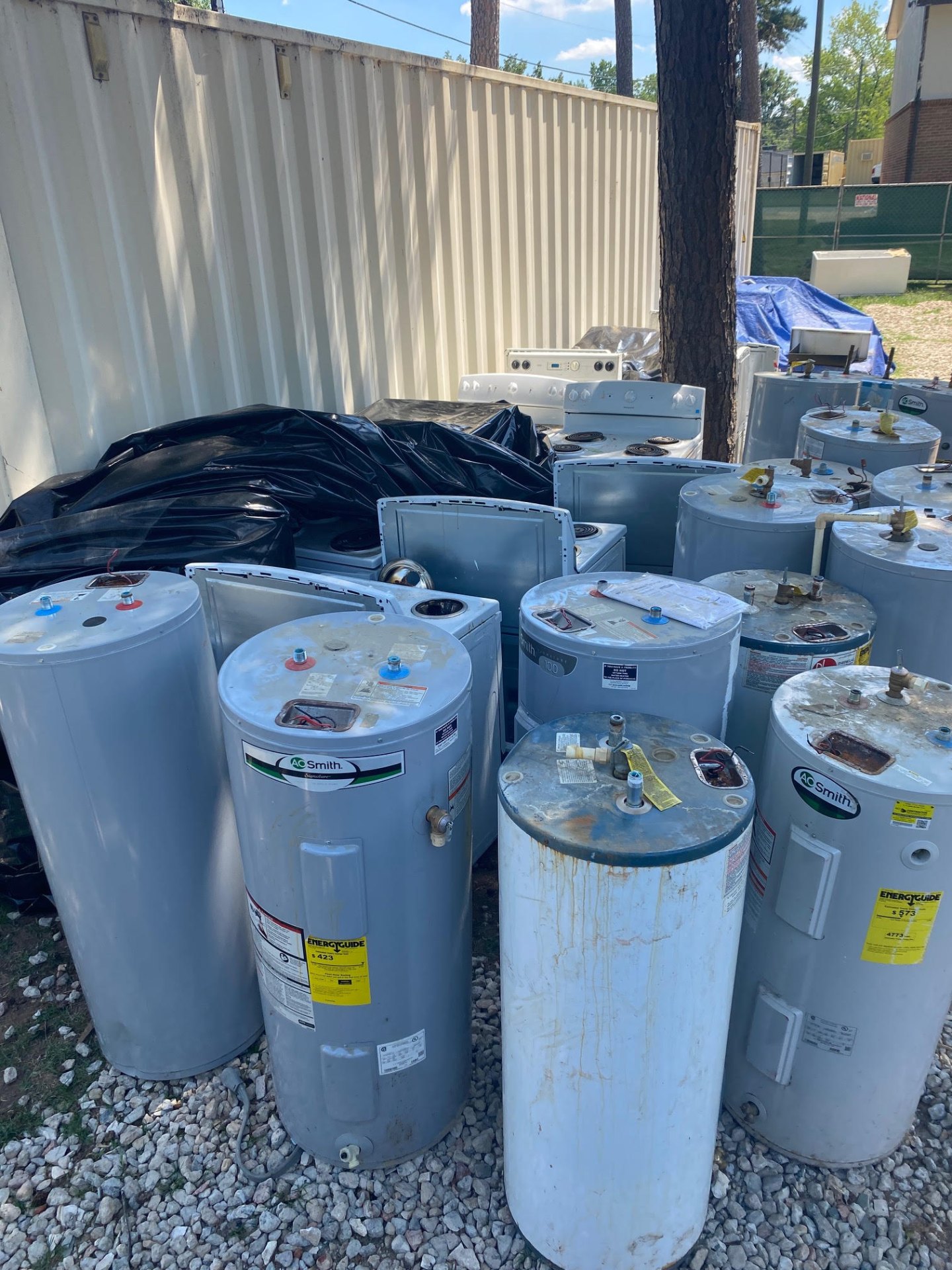 Before photo: stack of old water heaters and appliances hauled off by JB Strong in Concord, NC